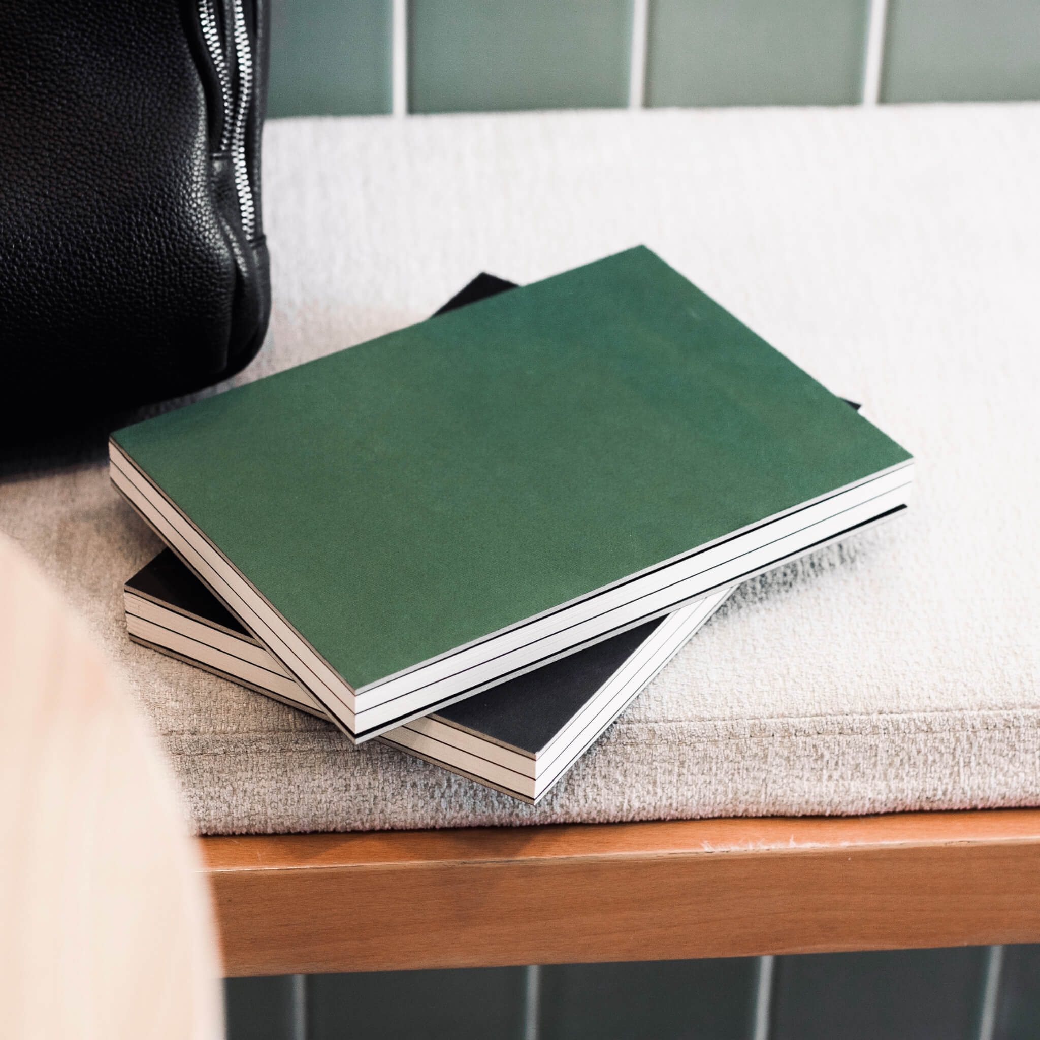 basenotes 1623 Paperbook in Green and Black covers styled in a minimalist lifestyle setting.
