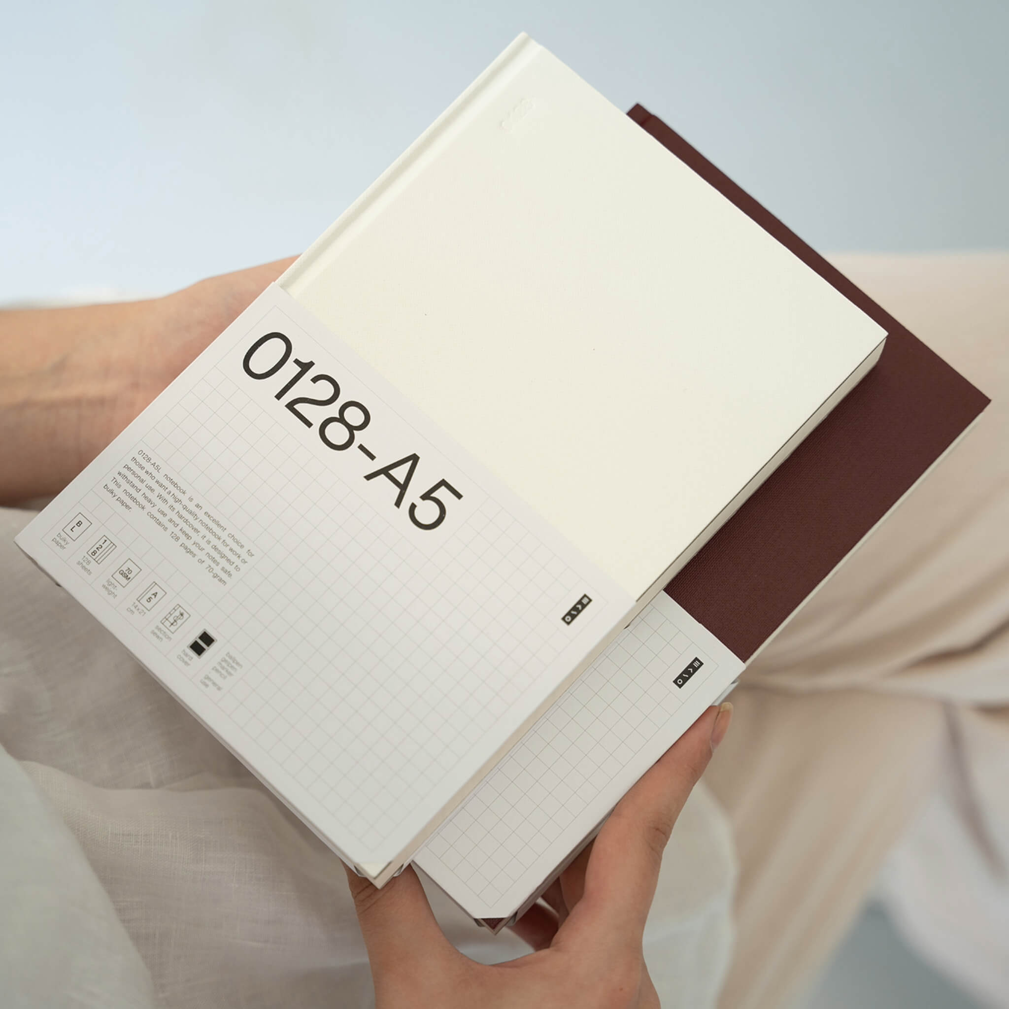 basenotes 0128 A5 Notebook in white with product sleeve showing technical details and minimal grid design.