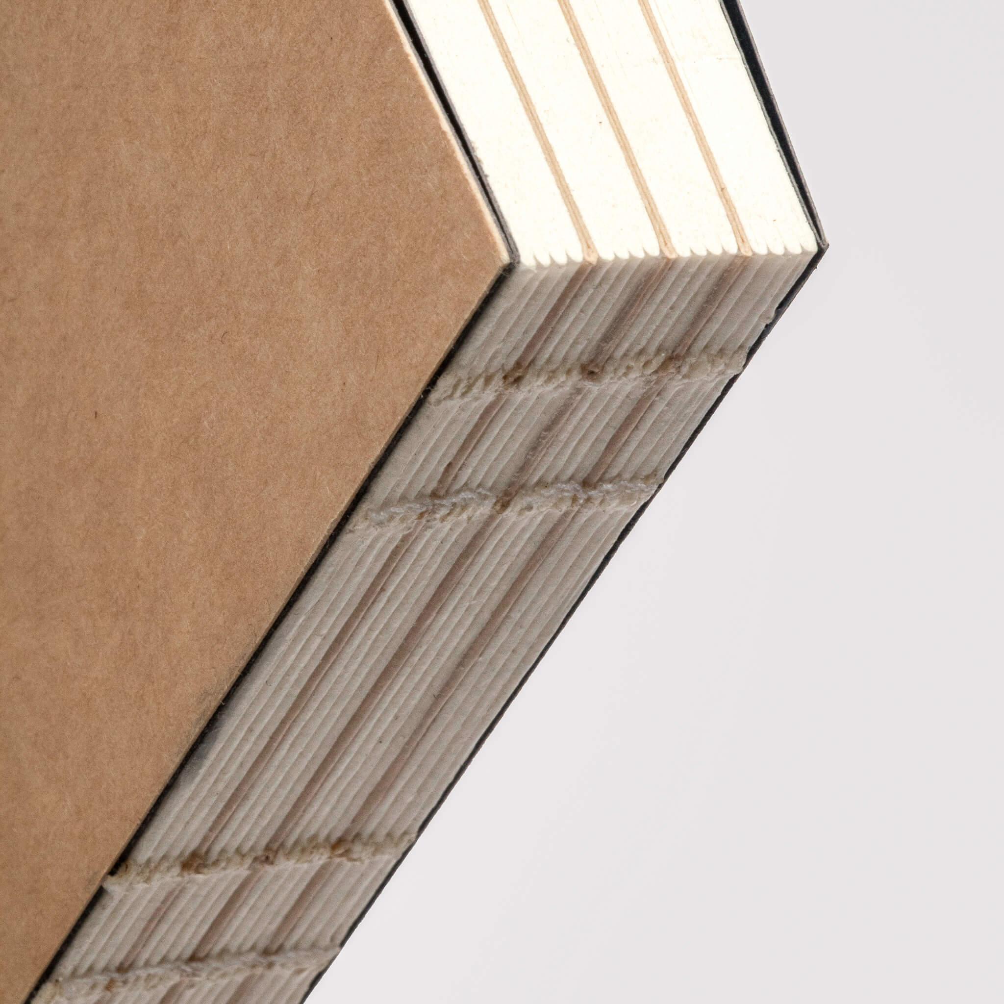 Macro view of the basenotes 0432 Notebook’s exposed thread binding, revealing the precise hand-sewn structure.