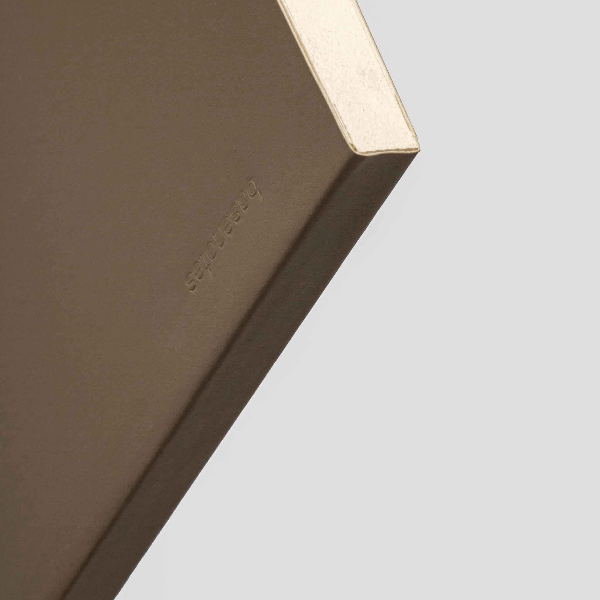 Close-up of basenotes 0480-A5 Notebook beige cover corner embossed with the basenotes logo.