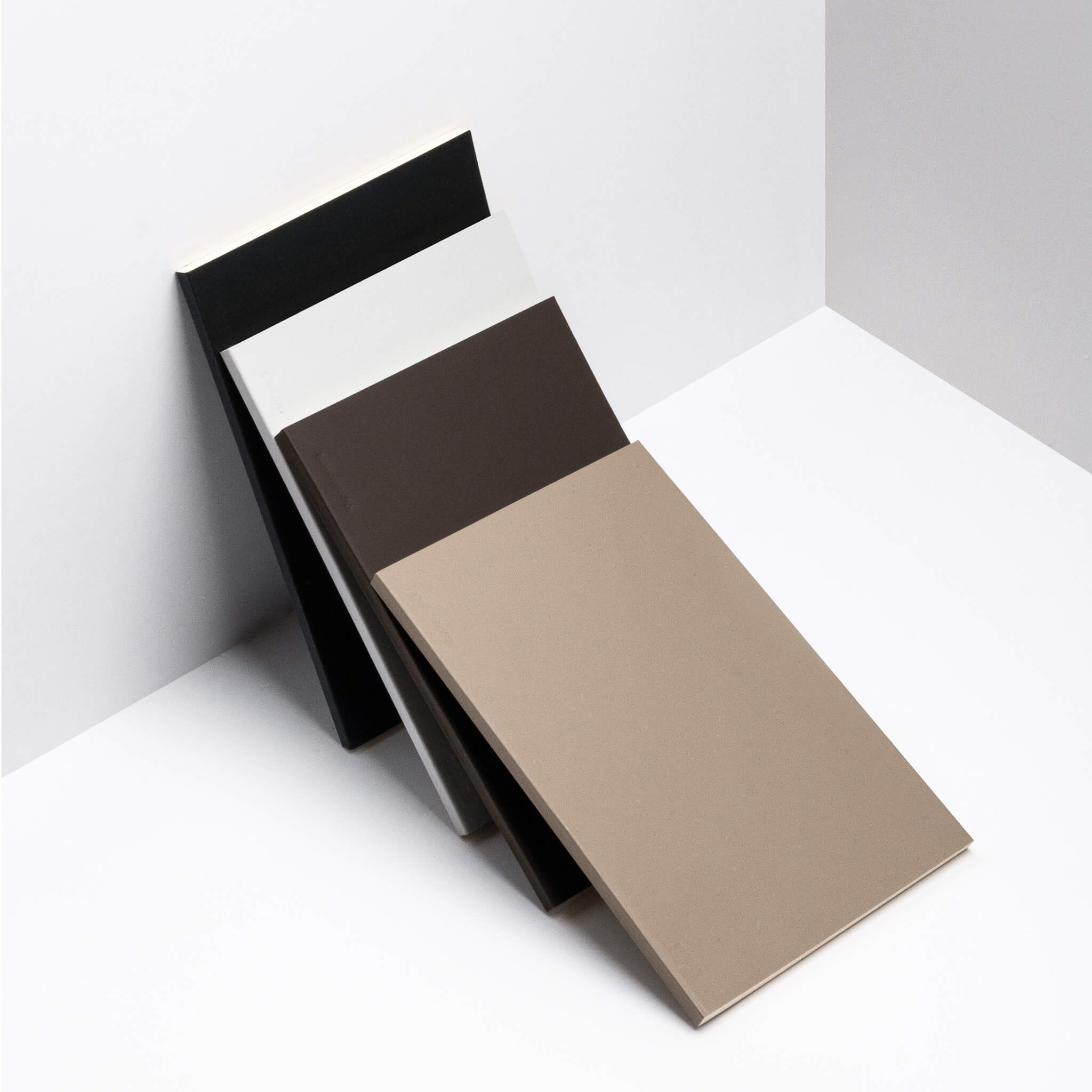 basenotes 0480 Notebooks displayed together in taupe, brown, grey, and black covers against white background.