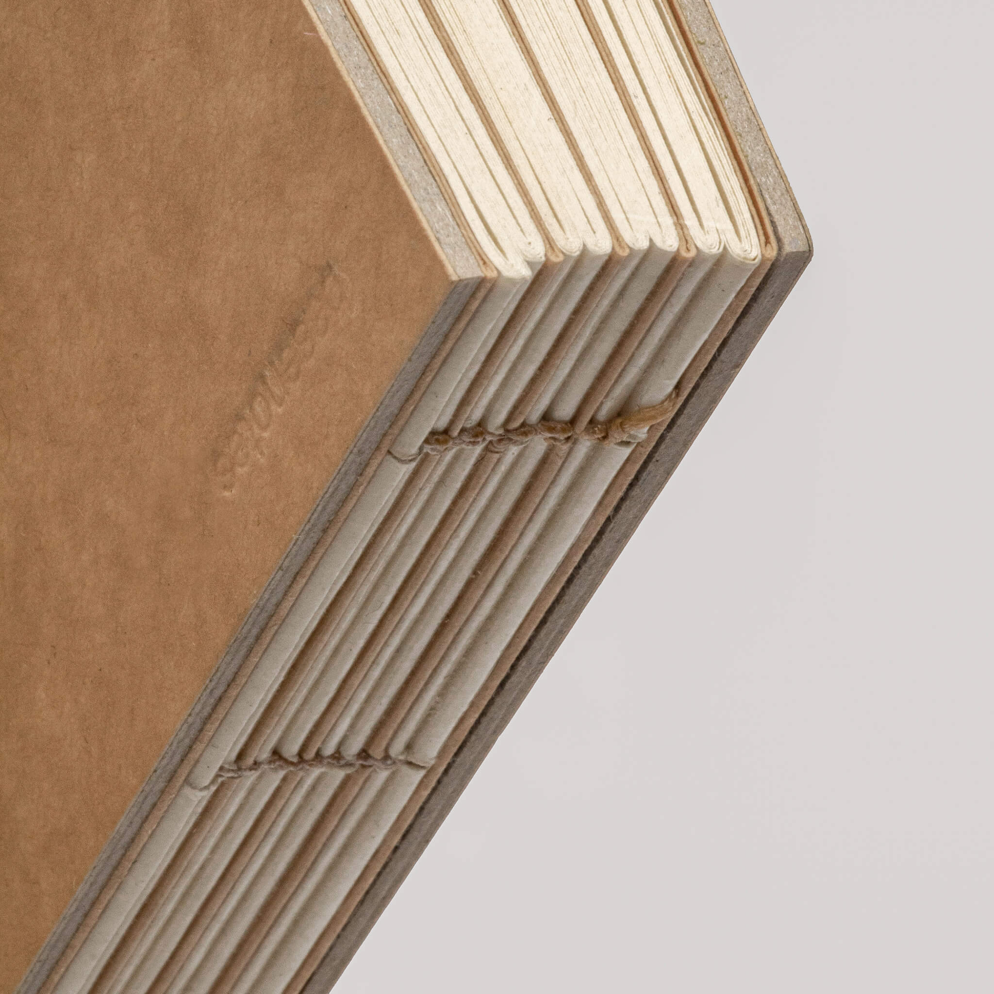 basenotes close-up of hand-stitched exposed binding on kraft 2222 Paperbook, showing durable lay-flat construction.