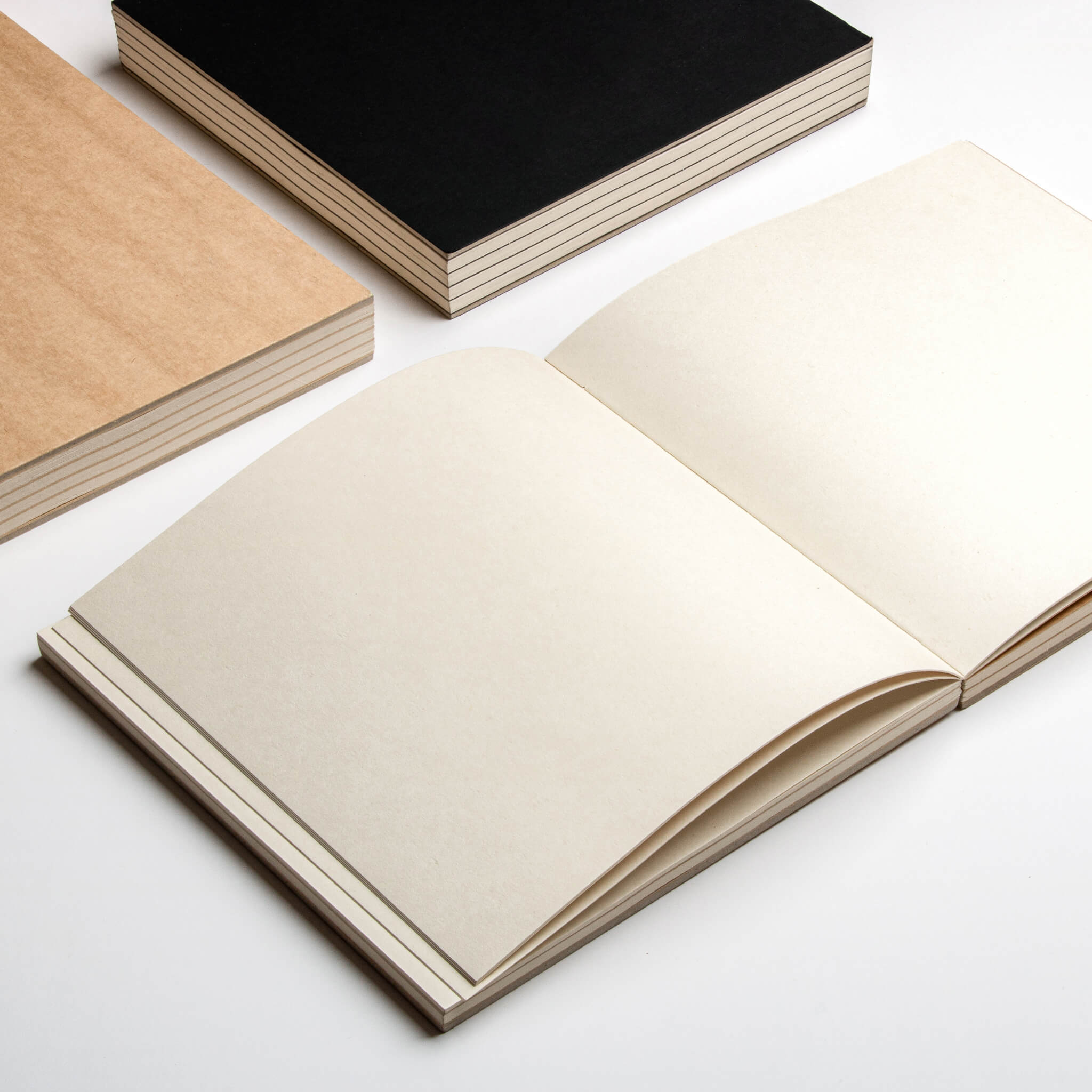 basenotes 2222 Paperbook open flat with cream pages, kraft and black covers displayed, handmade with exposed binding.