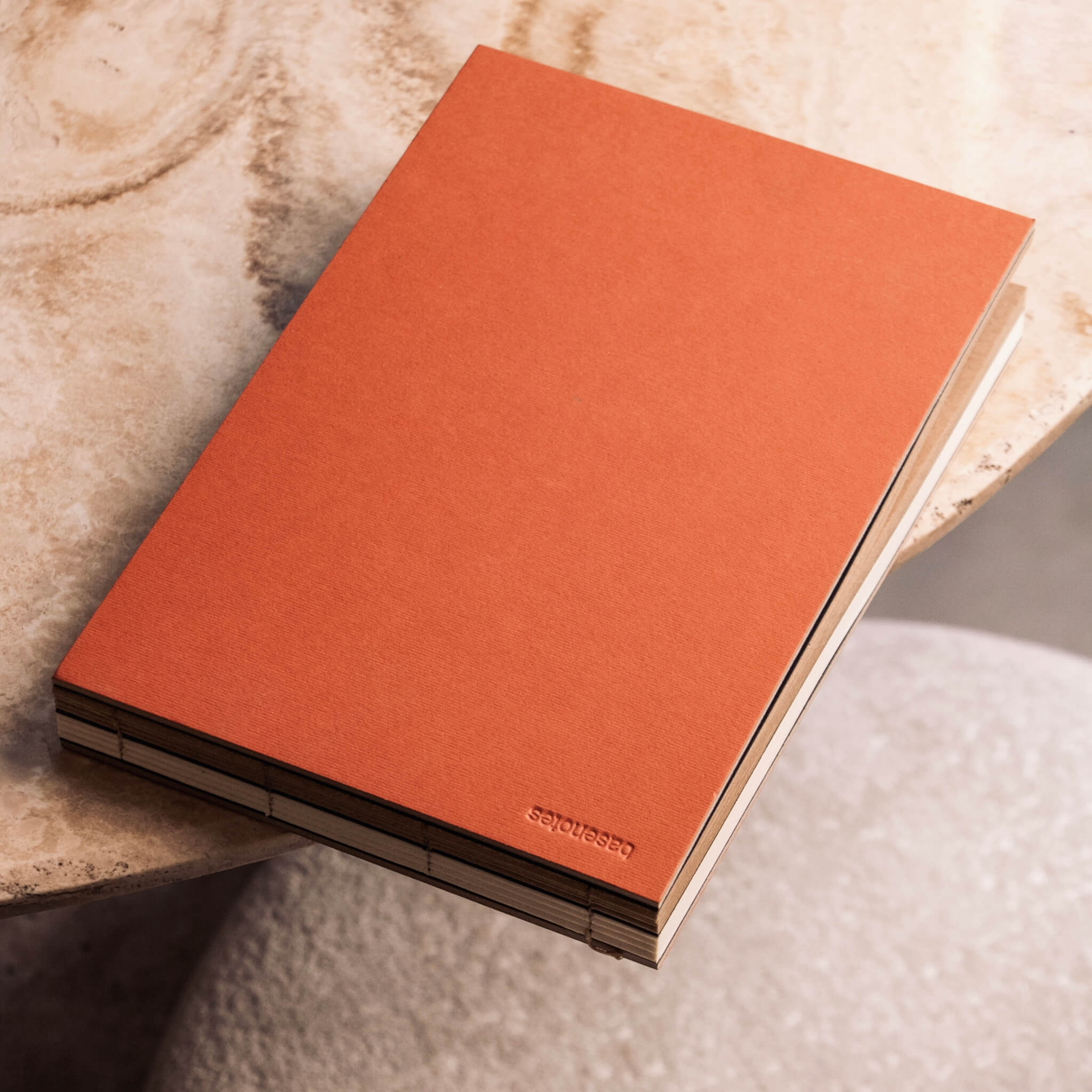 basenotes 2316mk landscape sketchbook with hand-stitched lay-flat binding, featuring a warm orange cover and dual white and kraft acid-free paper.