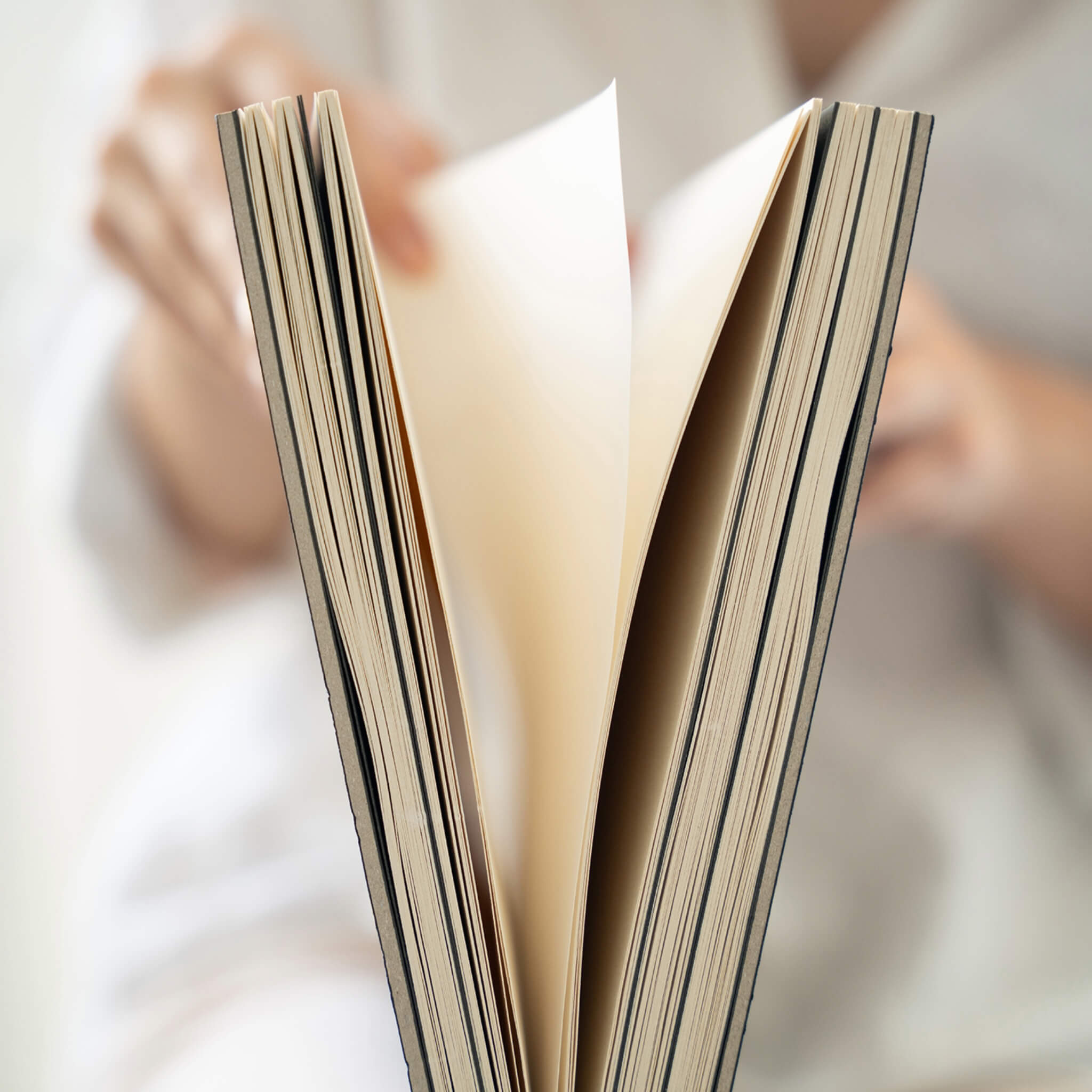 Close-up of pages being turned inside the basenotes 2333 Paperbook showing lay-flat design and textured sheets.