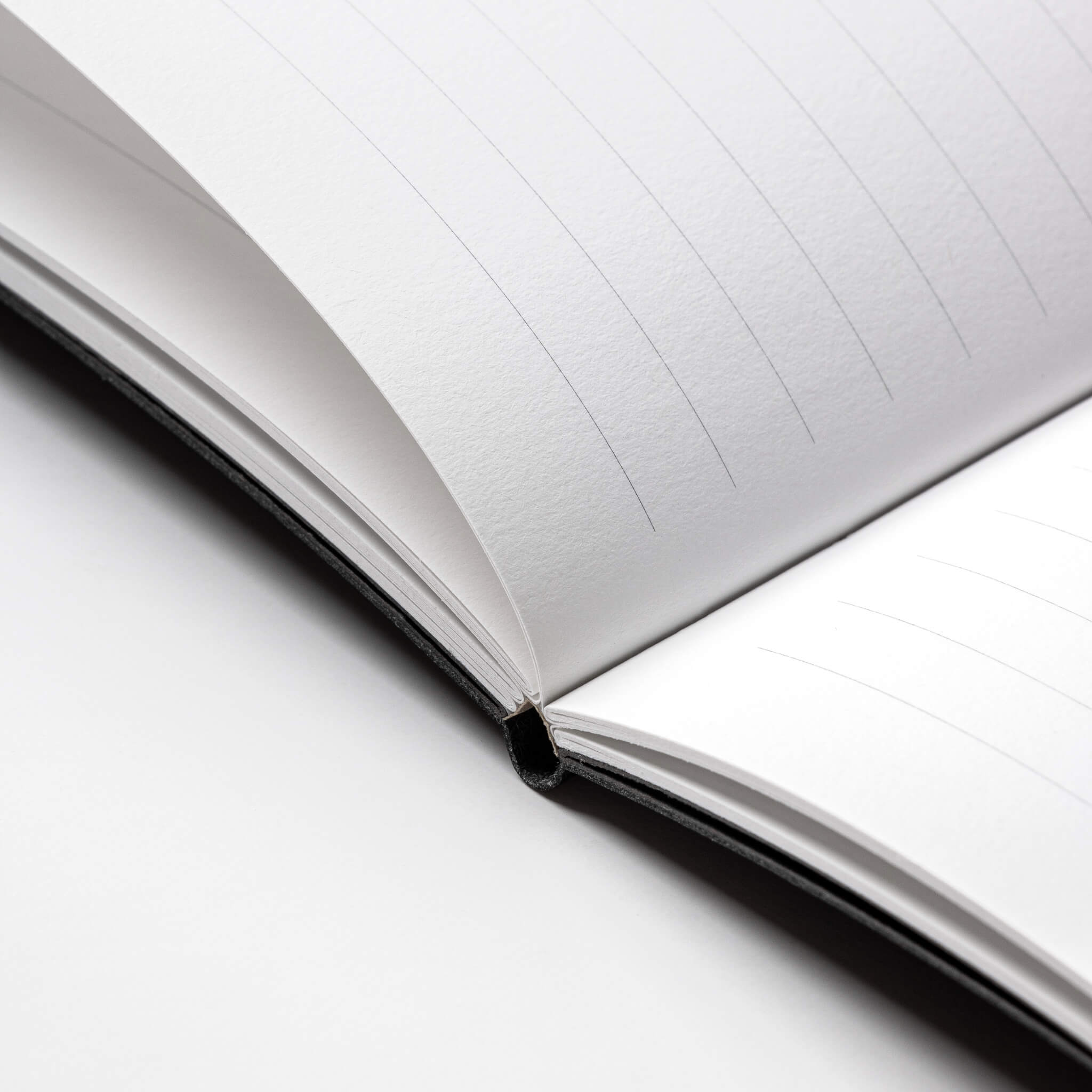 Close-up of the basenotes 4000 A5 Notebook’s lay-flat spine showing thread-sewn binding and premium writing paper texture.