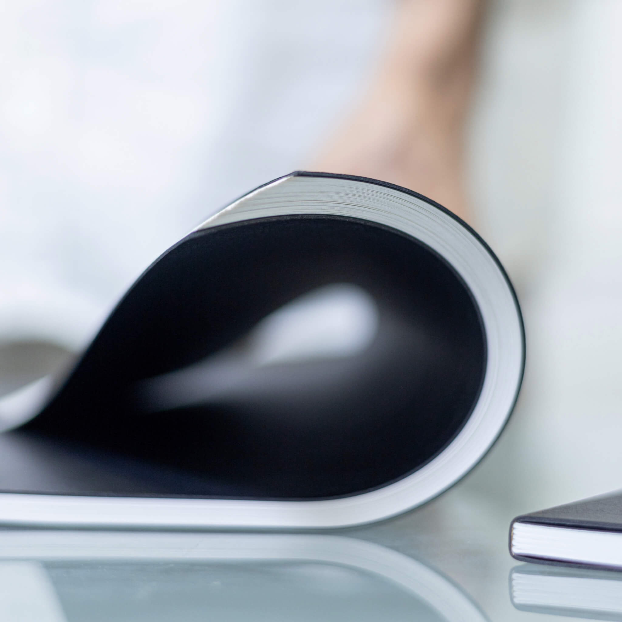 Basenotes 4000 A5 Notebook curved, showcasing flexible lay-flat binding and smooth lined paper ideal for pen writing.