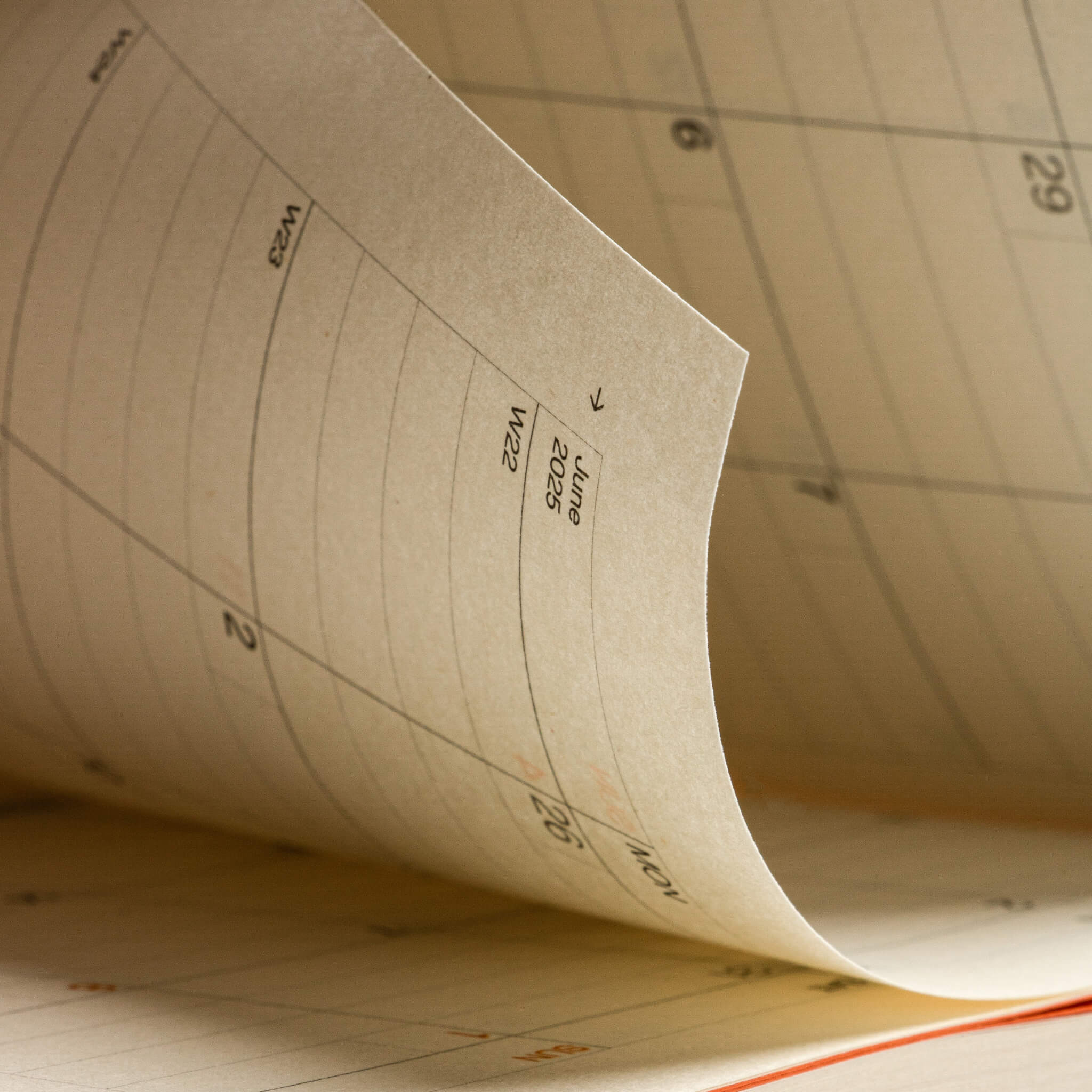 Close-up of the basenotes Planner calendar page showing June 2025 detail printed on softly textured FSC-certified paper with a warm natural tone.