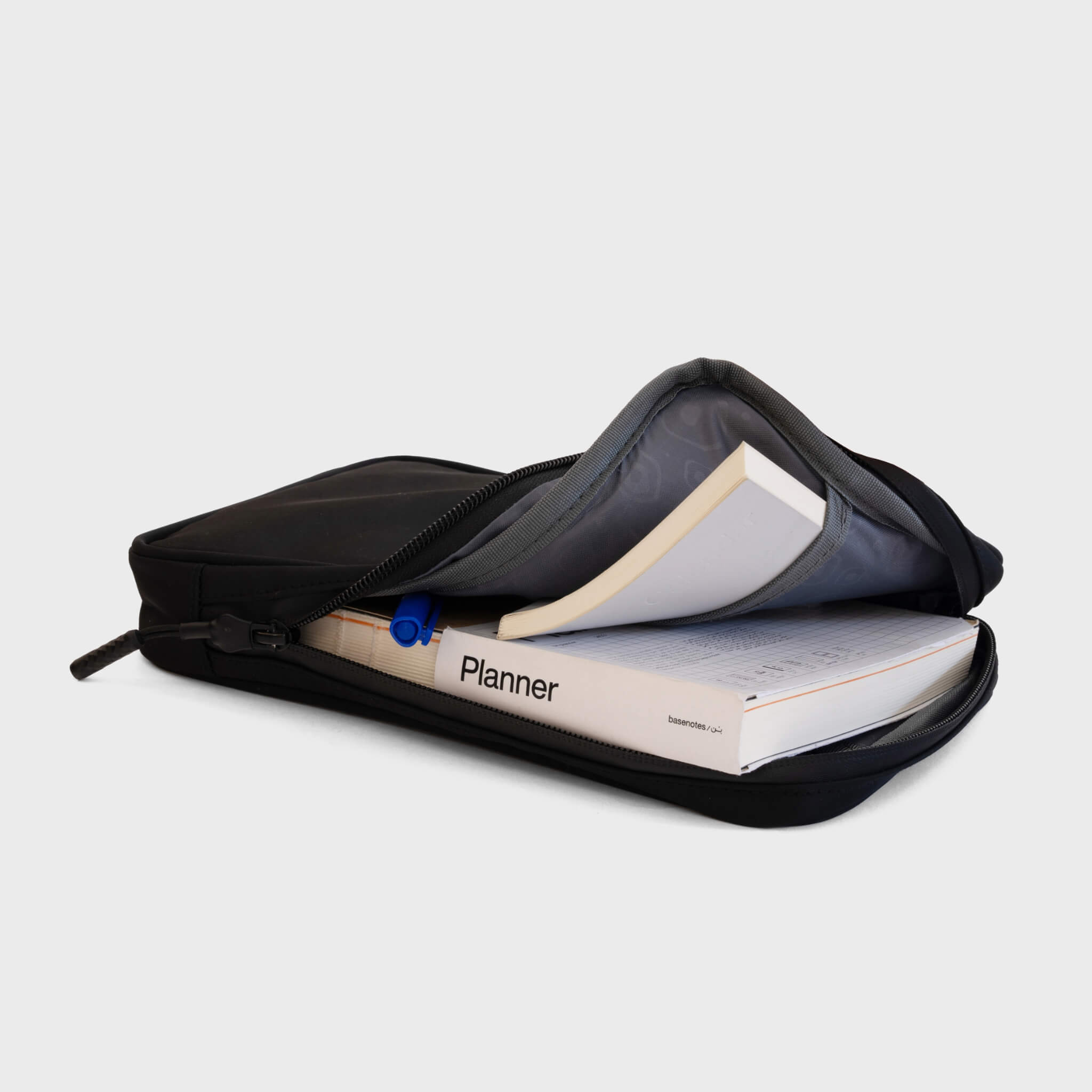 basenotes waterproof carry case open, holding multiple notebooks and a pen