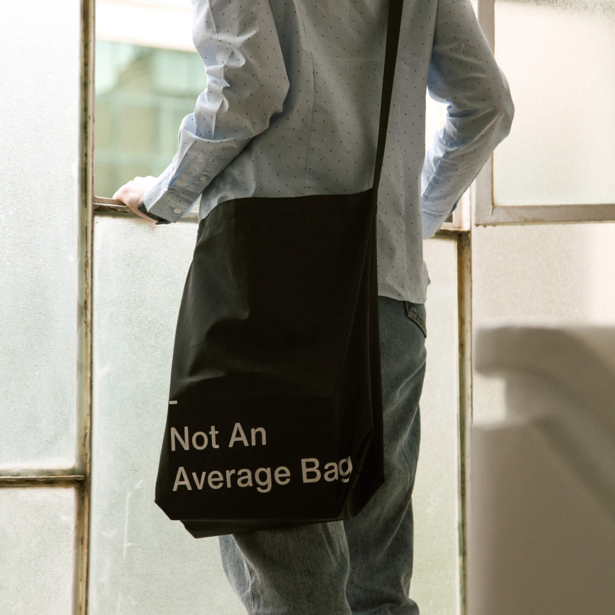basenotes waterproof utility tote worn on the shoulder in a modern lifestyle setting