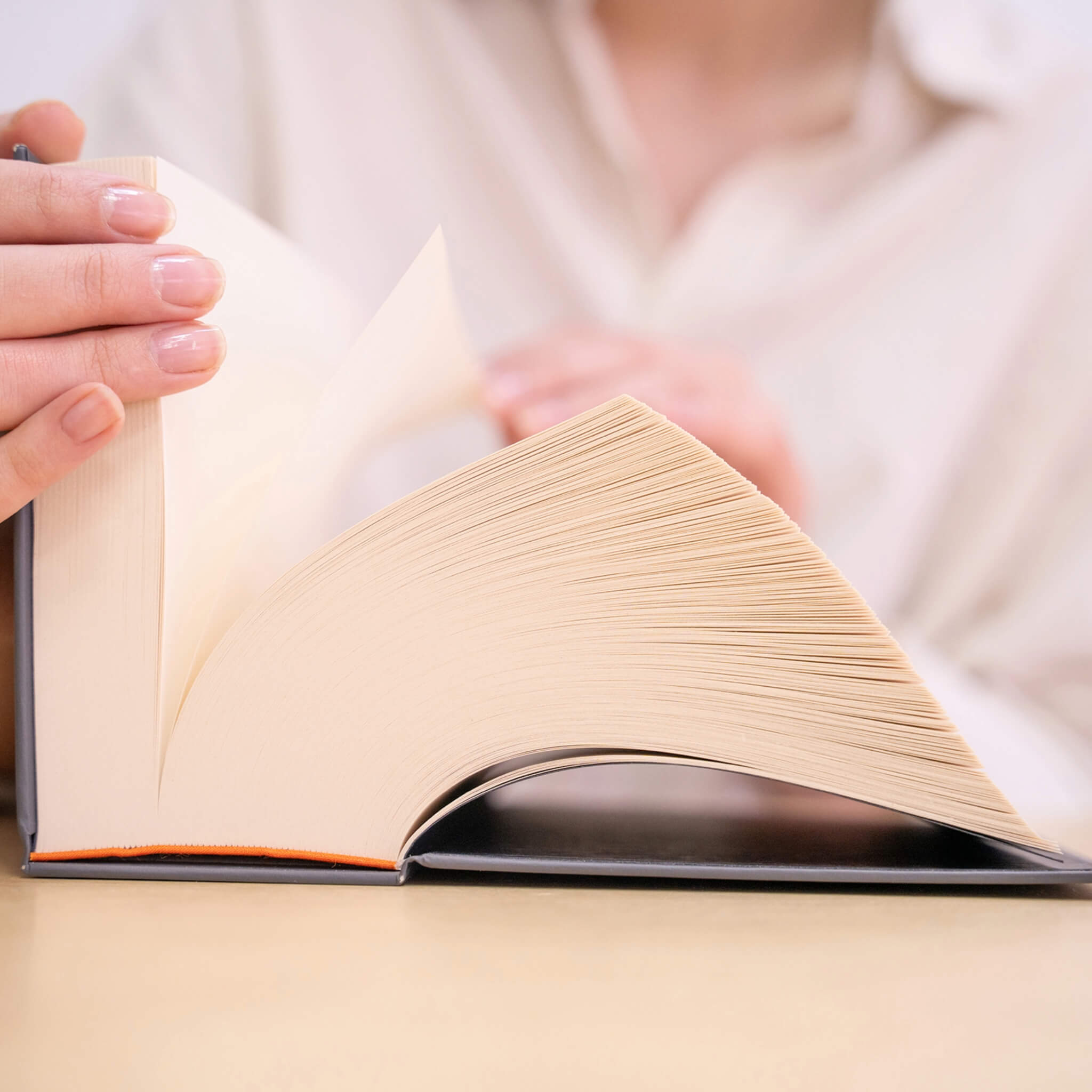 Person flipping through the basenotes 0512 Notebook, revealing hundreds of creamy, acid-free pages bound by hand for lasting durability.