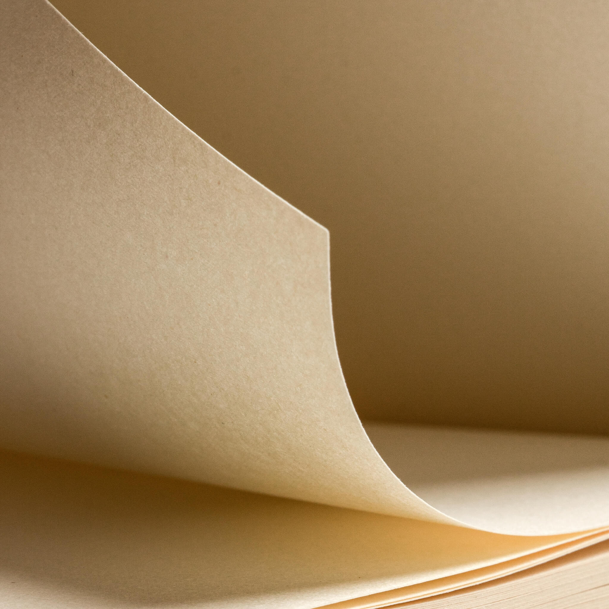 Detailed view of a page being turned in the basenotes 0512 Notebook, capturing the soft curve and thickness of its 70 GSM bulky FSC-certified paper.
