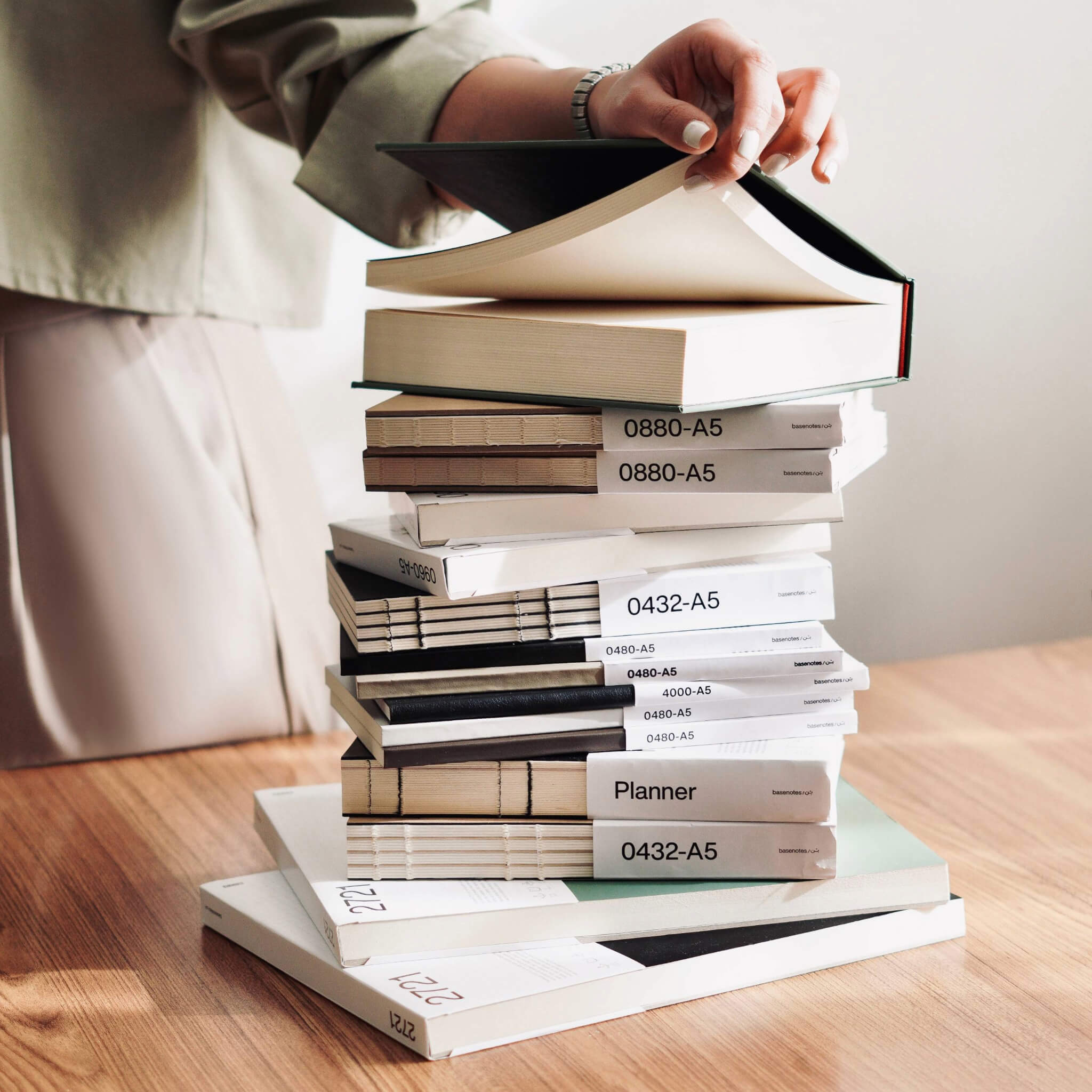 A stacked selection of handmade notebooks, sketchbooks, planners, and paper tools, representing the full basenotes range.