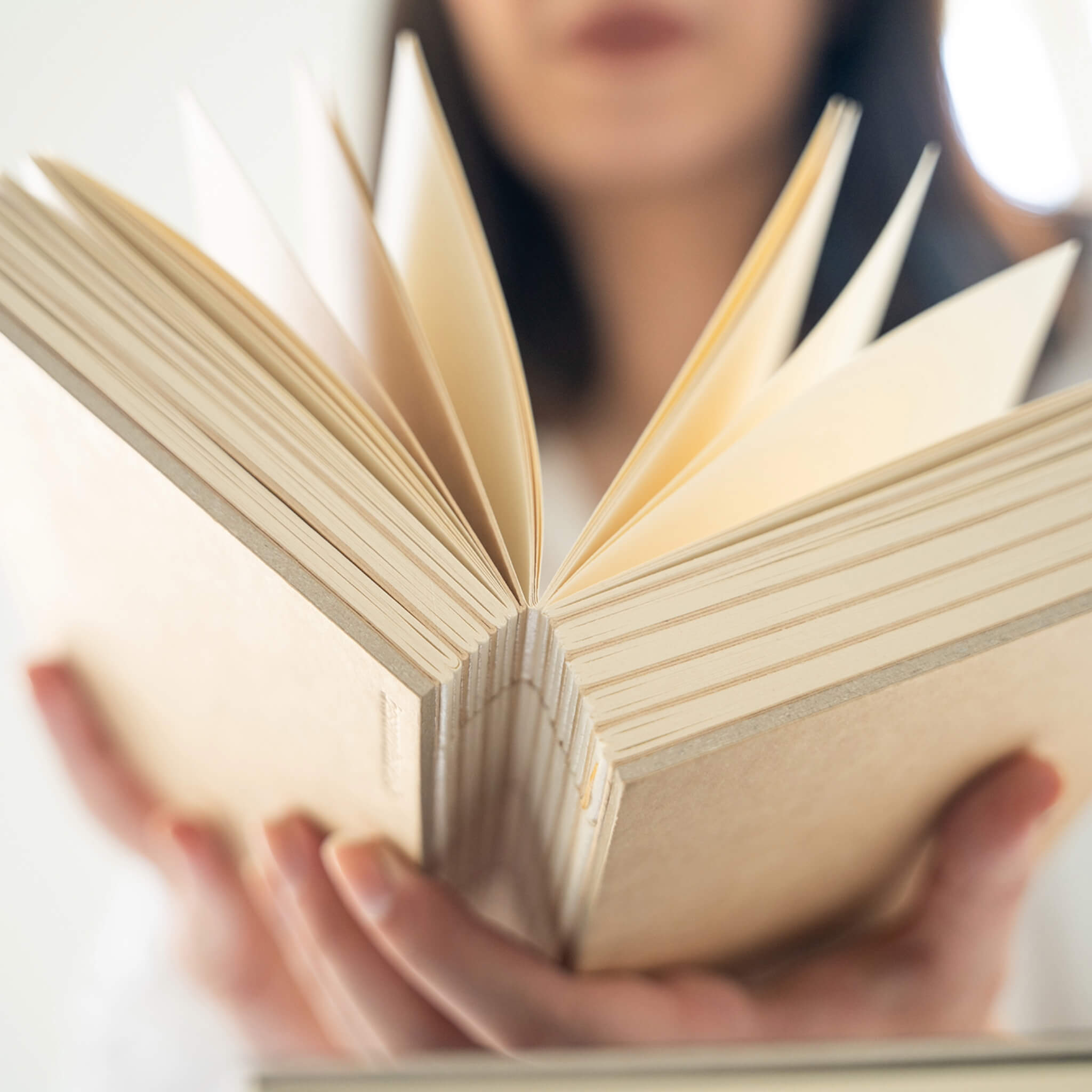 Open basenotes 1216 Kraft Paperbook displayed in hands, highlighting lay-flat binding and smooth blank pages.