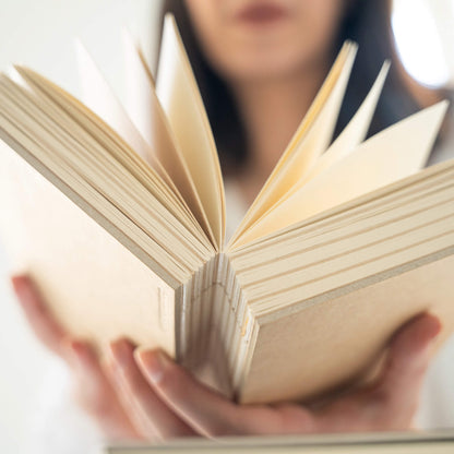 Open basenotes 1216 Kraft Paperbook displayed in hands, highlighting lay-flat binding and smooth blank pages.