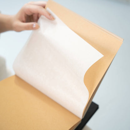 Interior view of a square sketchbook showing 120 GSM acid-free kraft paper with interleaved tracing sheets