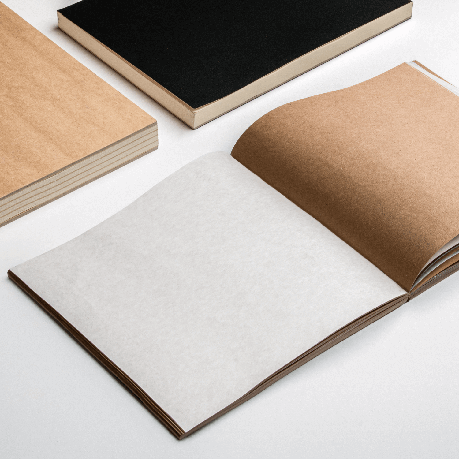 Lay-flat square sketchbook with kraft paper pages and interleaved tracing sheets for full page access