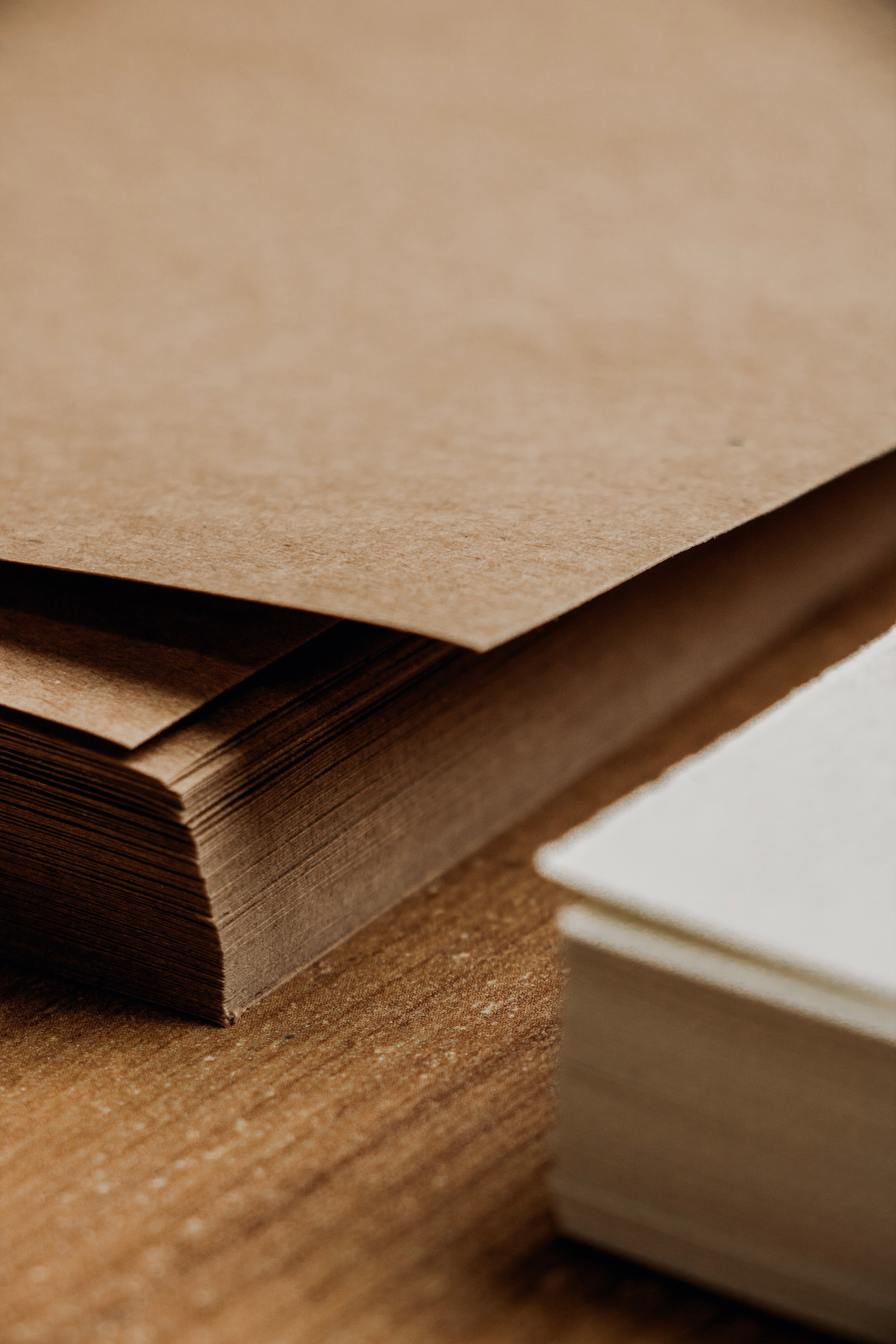 Close-up of Kraft and white plain paper on a wooden surface