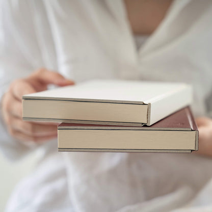 Close-up of basenotes 0128 Notebook edges in maroon and white, showing fine craftsmanship and clean binding.