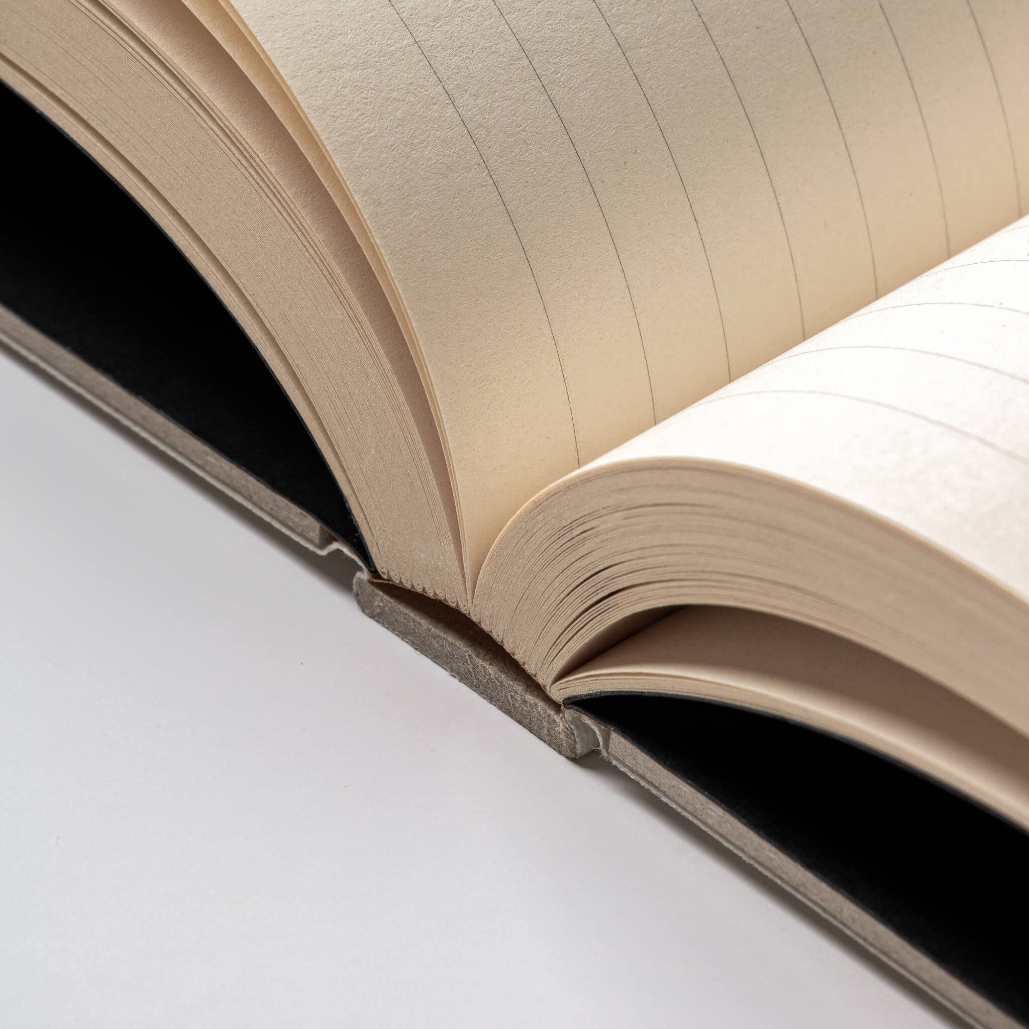 Close-up of basenotes 0128 Notebook showing lay-flat binding with sturdy handmade spine and lined interior pages.
