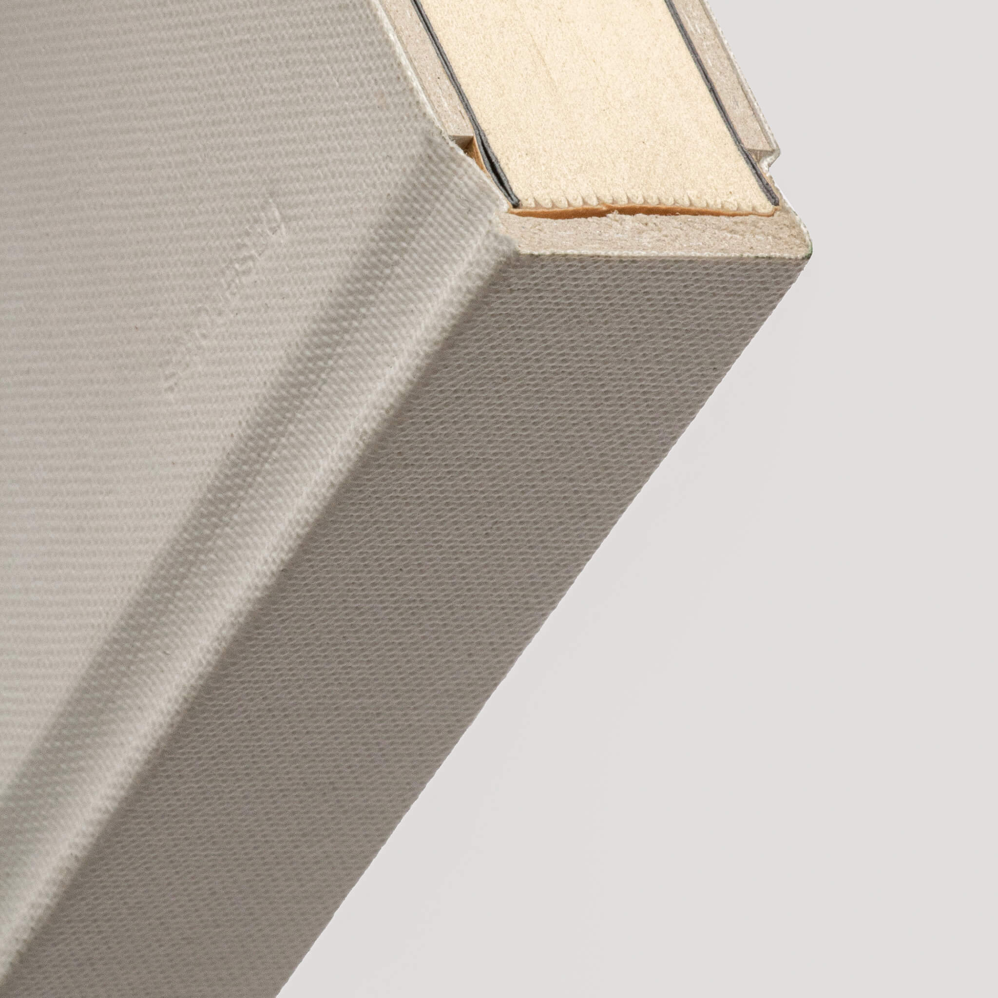 Close-up of basenotes 0128 Notebook corner in white fabric cover showing embossed branding and textured surface.