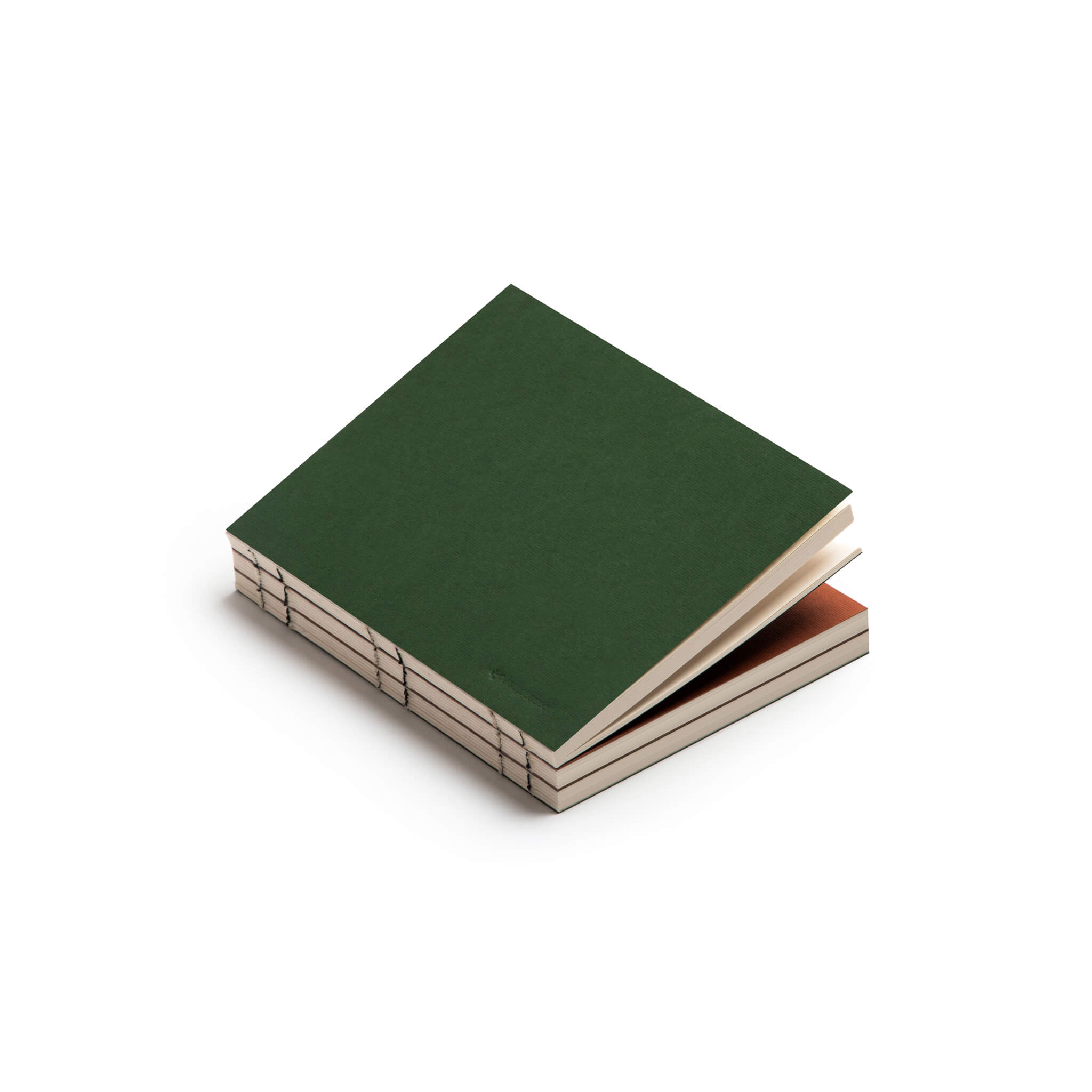 Stack of basenotes 0144 notebooks with green cover and exposed spine stitching, showing precise hand-bound craftsmanship.