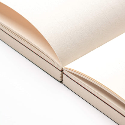 Close-up of basenotes 0144 Notebook showing thread-sewn exposed binding that allows pages to open fully flat.