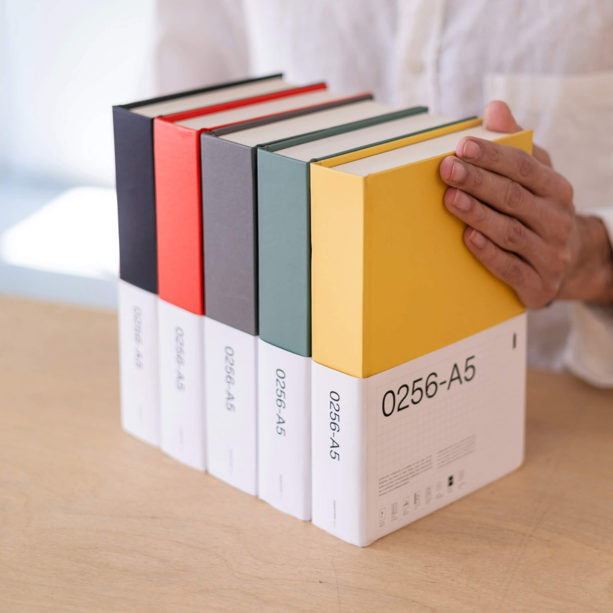 Full basenotes 0256 A5 Notebook collection in yellow, green, red, grey, and black, with minimalist white sleeves and grid-label design.