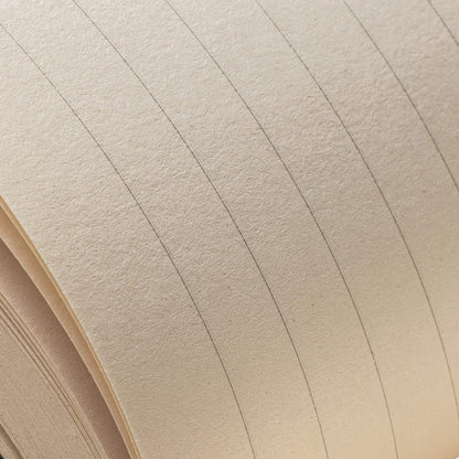 Close-up of the basenotes 0432 Notebook showing its textured, acid-free ruled pages with fine grey lines.