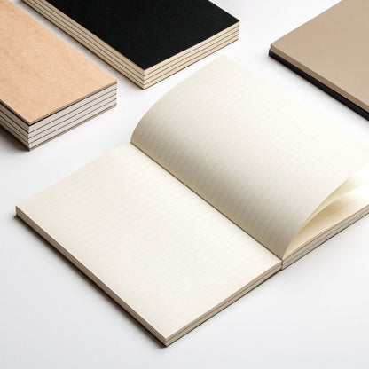 Open basenotes 0432 Notebook with other kraft and black editions stacked beside it on a white background.