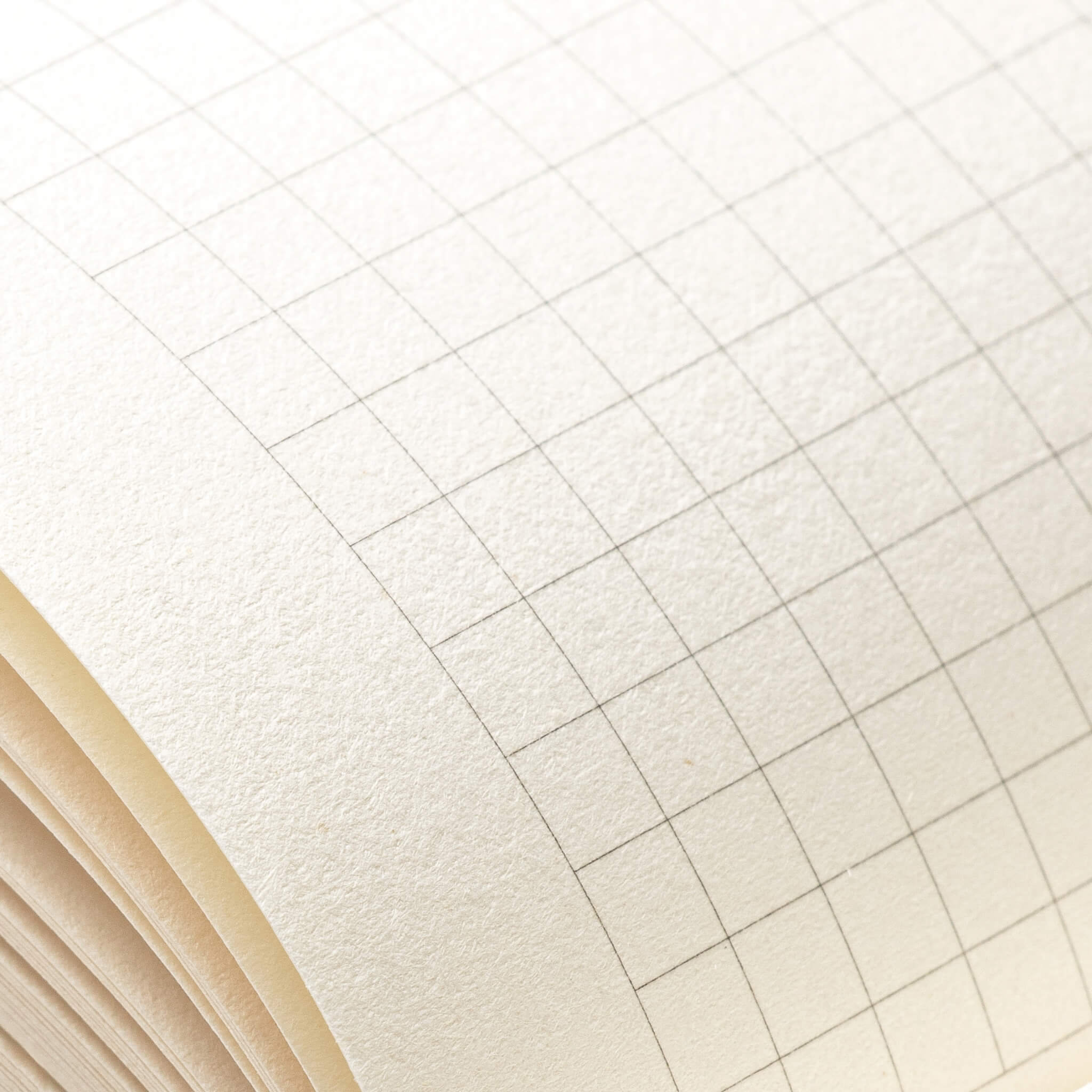Close macro shot of basenotes 0480-A5 grid paper showing detailed line printing and subtle paper grain.