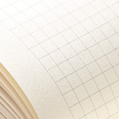 Close macro shot of basenotes 0480-A5 grid paper showing detailed line printing and subtle paper grain.