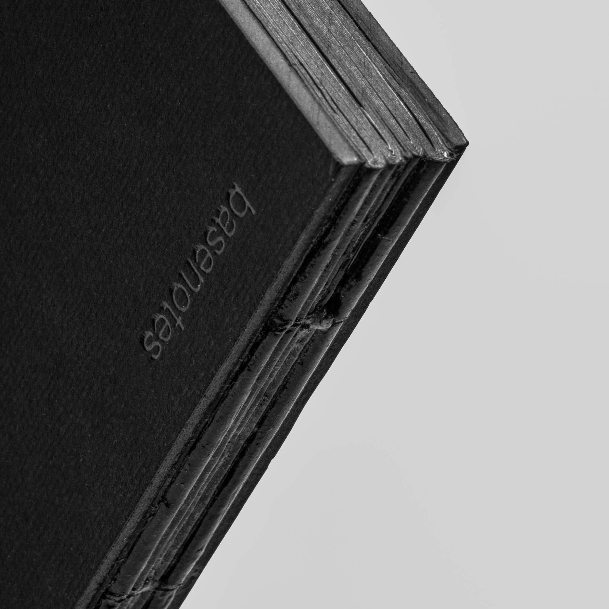 Embossed basenotes logo on the spine of the 1623B Black Pape rbook with visible hand-stitched binding.