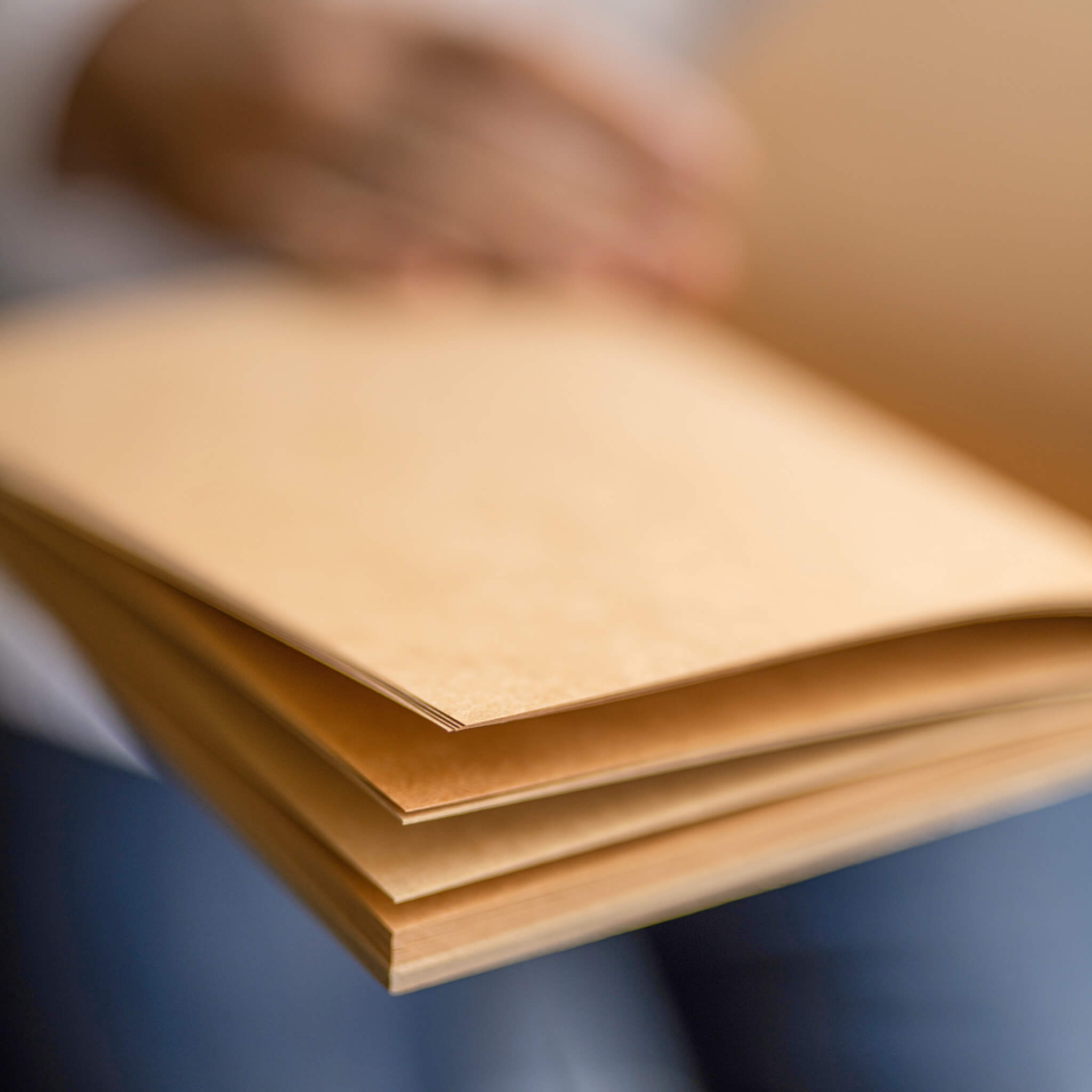Person holding an open basenotes 1623K Kraft Paper book, revealing natural paper texture and hand-sewn binding.