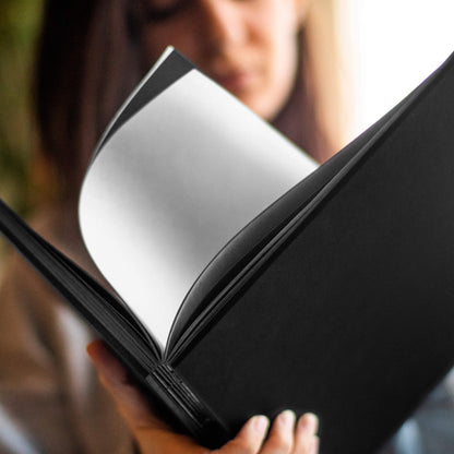 Person flipping through the basenotes 2222 black Paperbook, revealing tracing paper between the pages.