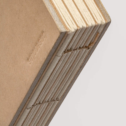 Close-up of the basenotes 2316 kraft sketchbook spine highlighting hand-stitched binding and embossed logo.