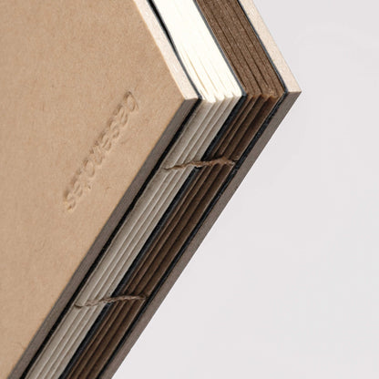 Close-up of basenotes 2316M Paper book showing exposed hand-sewn binding and alternating Kraft and multimedia paper sections.