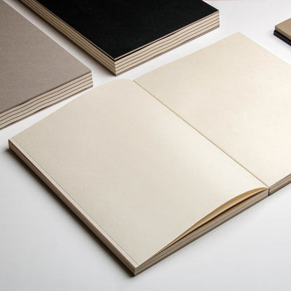 basenotes 2333 Paperbook opened flat showing cream pages and lay-flat binding, surrounded by other colour covers.