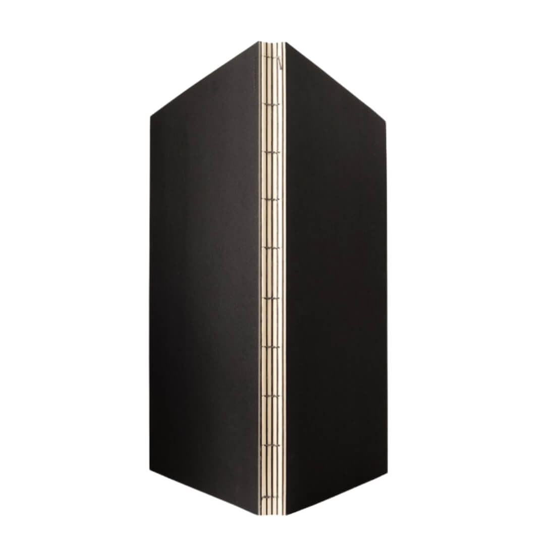Hand-stitched lay-flat binding of a sketchbook, showing exposed spine and durable construction.