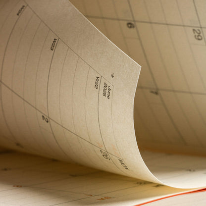 Close-up of the basenotes Planner calendar page showing June 2025 detail printed on softly textured FSC-certified paper with a warm natural tone.