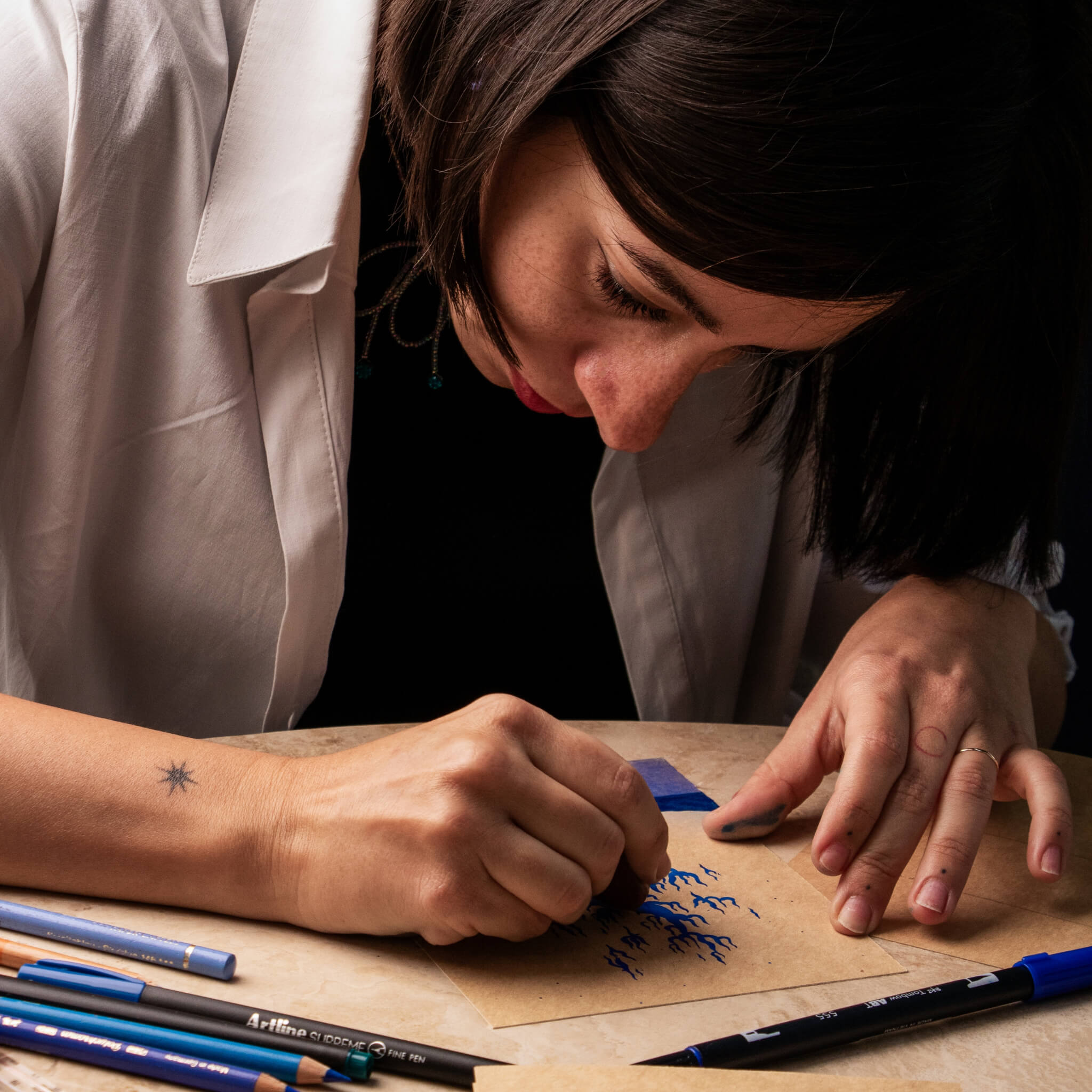 Artist Shide painting a custom basenotes paperbook by hand, capturing the detail and process of the collaboration
