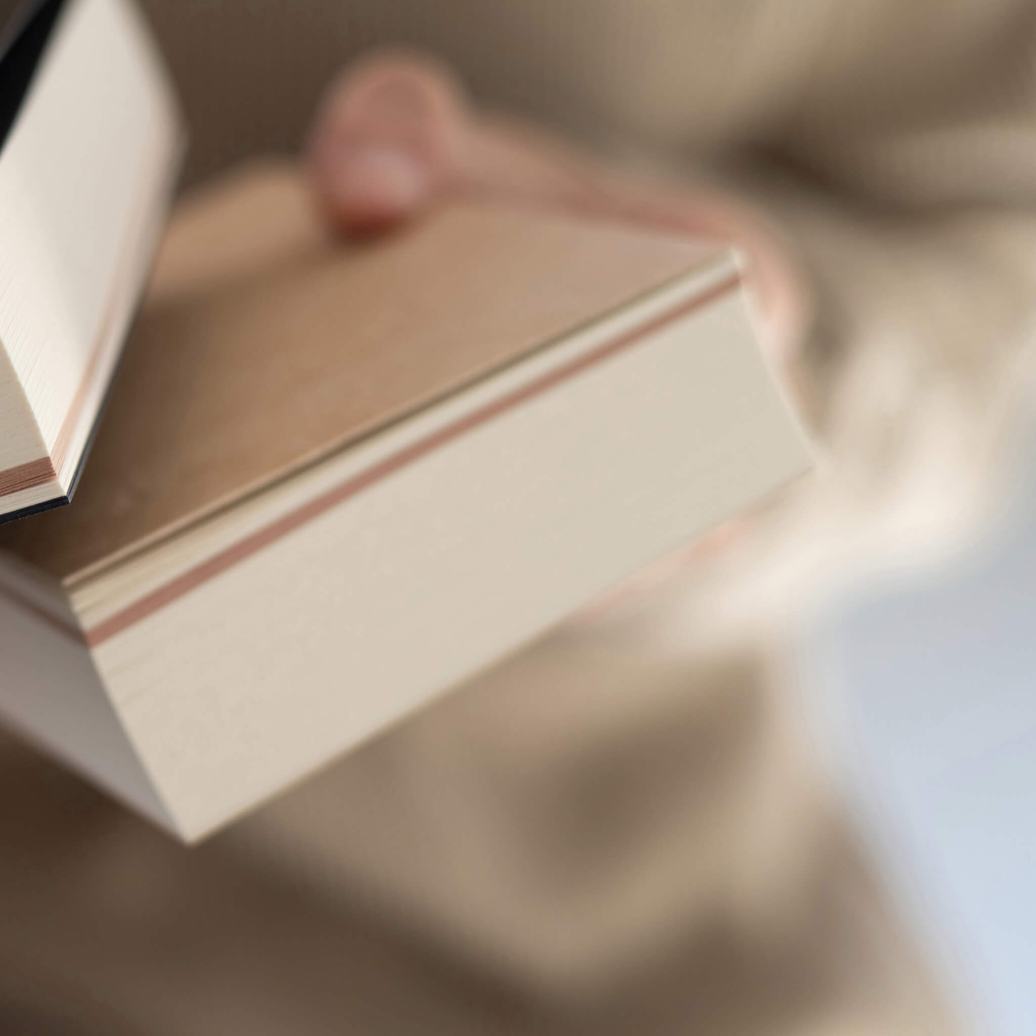 basenotes Tracker Notebooks stacked together in kraft and black covers, showcasing minimalist exposed binding.