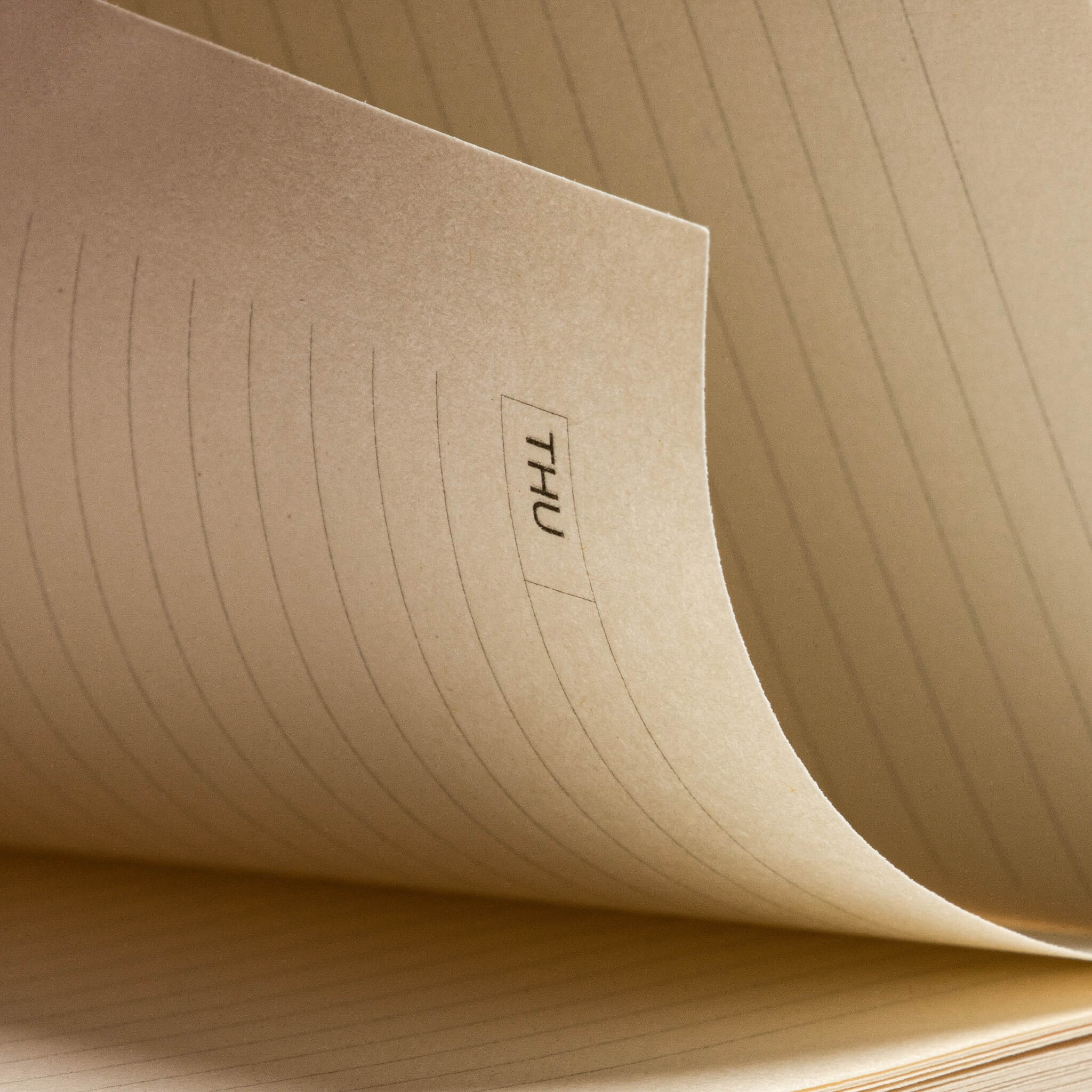 Macro shot of basenotes Tracker Notebook daily layout with weekday header printed on cream paper.