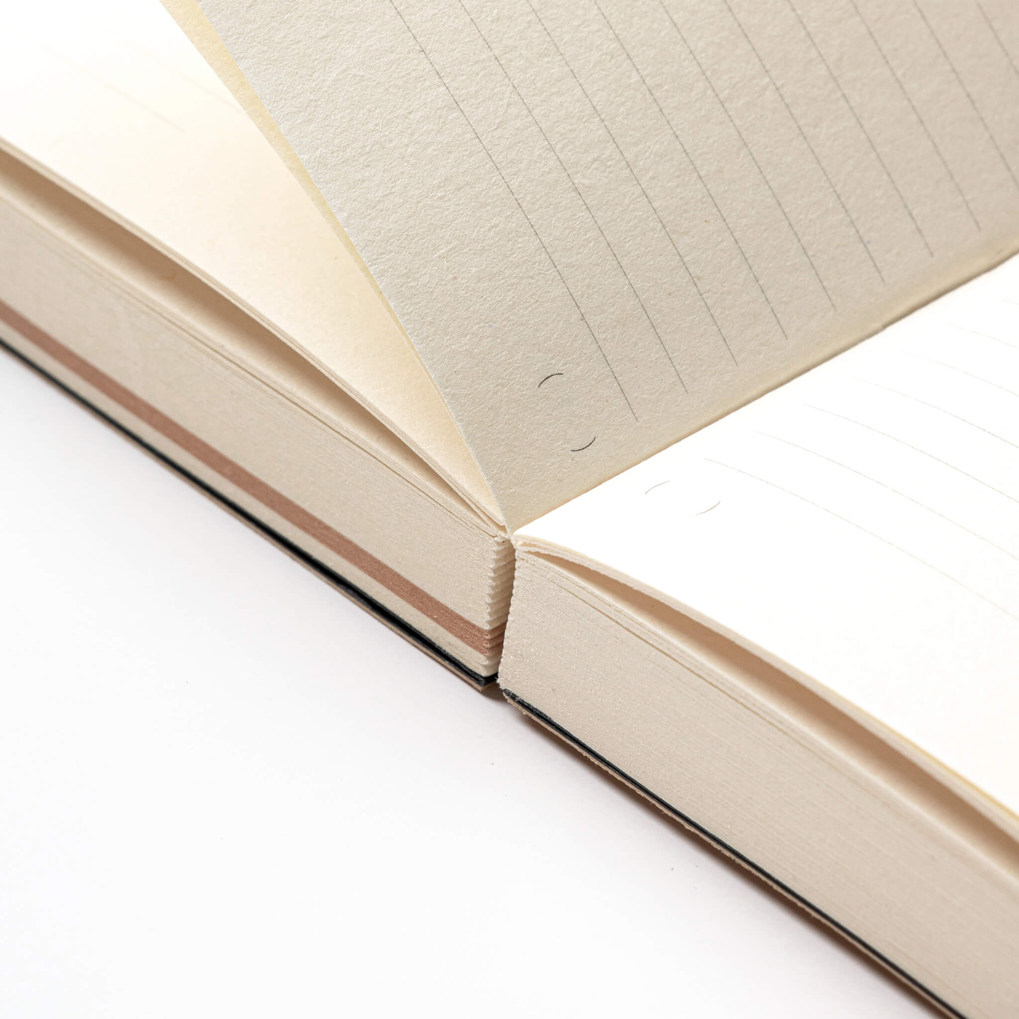 basenotes Tracker Notebook open on a flat surface, highlighting its lay-flat hand-sewn binding.