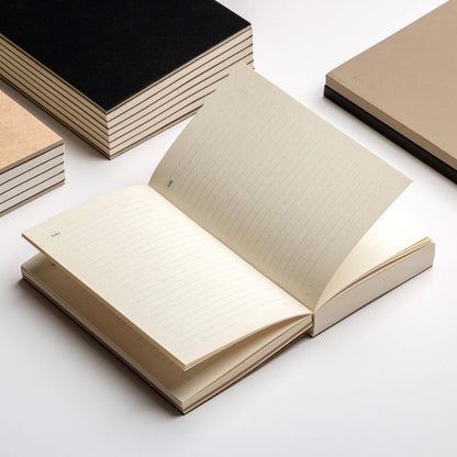 Open basenotes Tracker Notebook on a desk surrounded by other notebooks, showing functional daily layout.