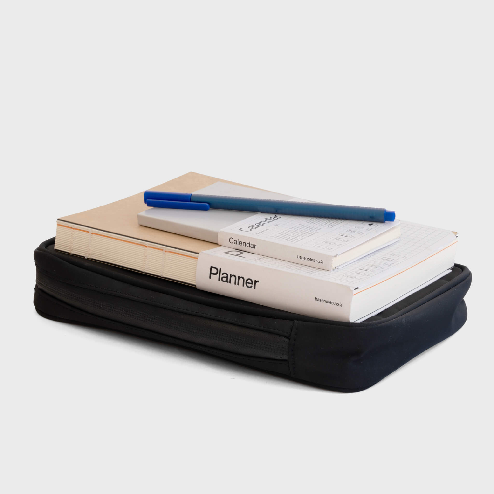 basenotes waterproof notebook case showing capacity with notebooks and planner stacked on top