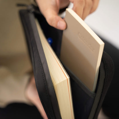 Notebook being inserted into basenotes waterproof zippered notebook cover