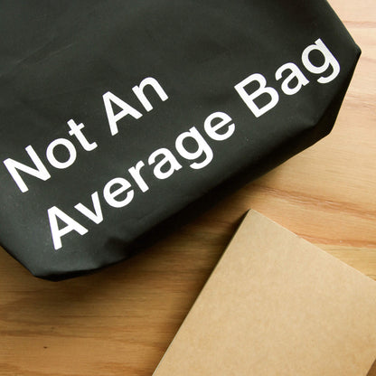 basenotes waterproof black utility tote featuring “Not An Average Bag” text detail