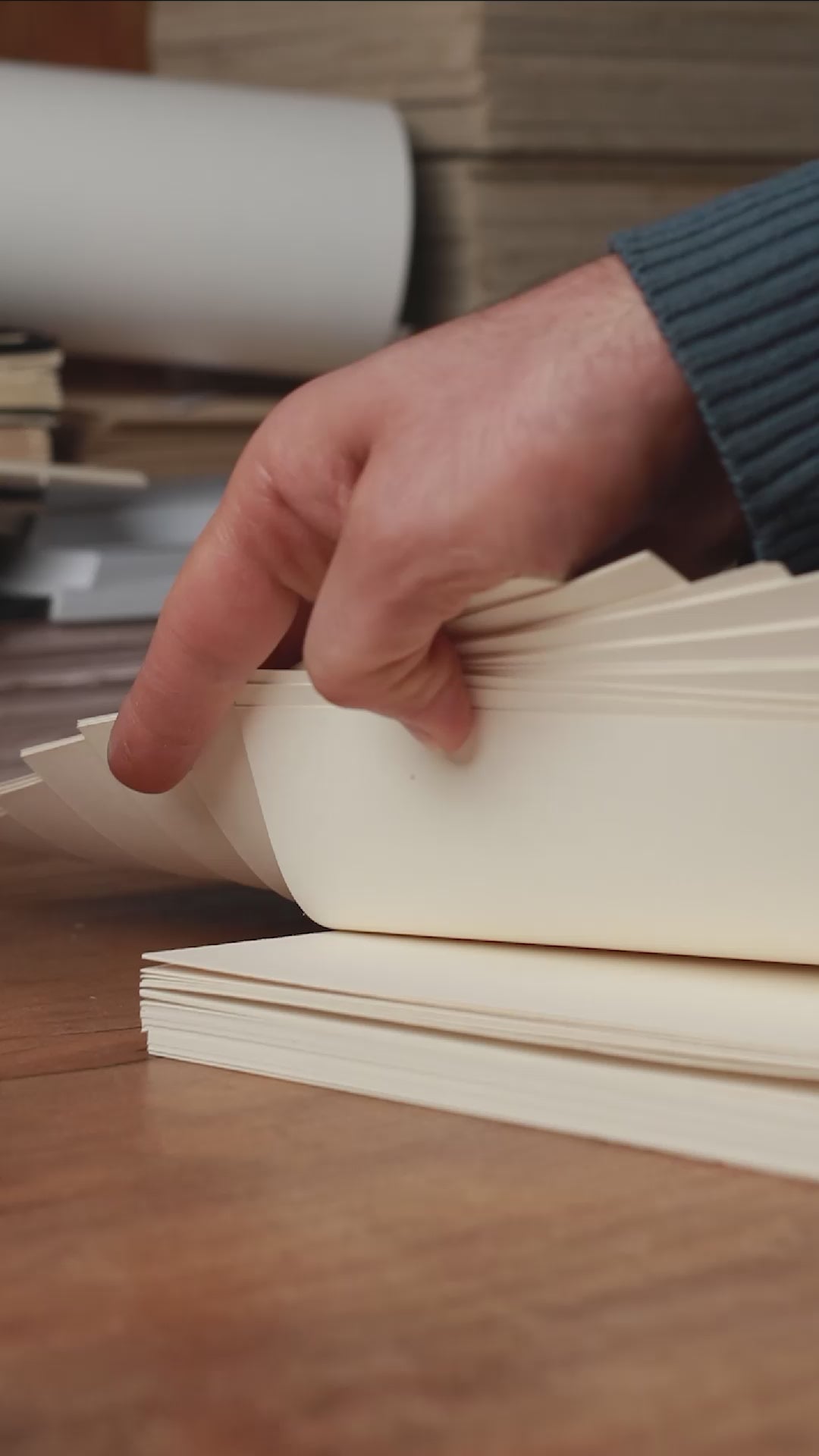 Load video: Close-up of the hand-stitching process, showing thread pulled carefully through folded paper to create a basenotes handmade notebook.