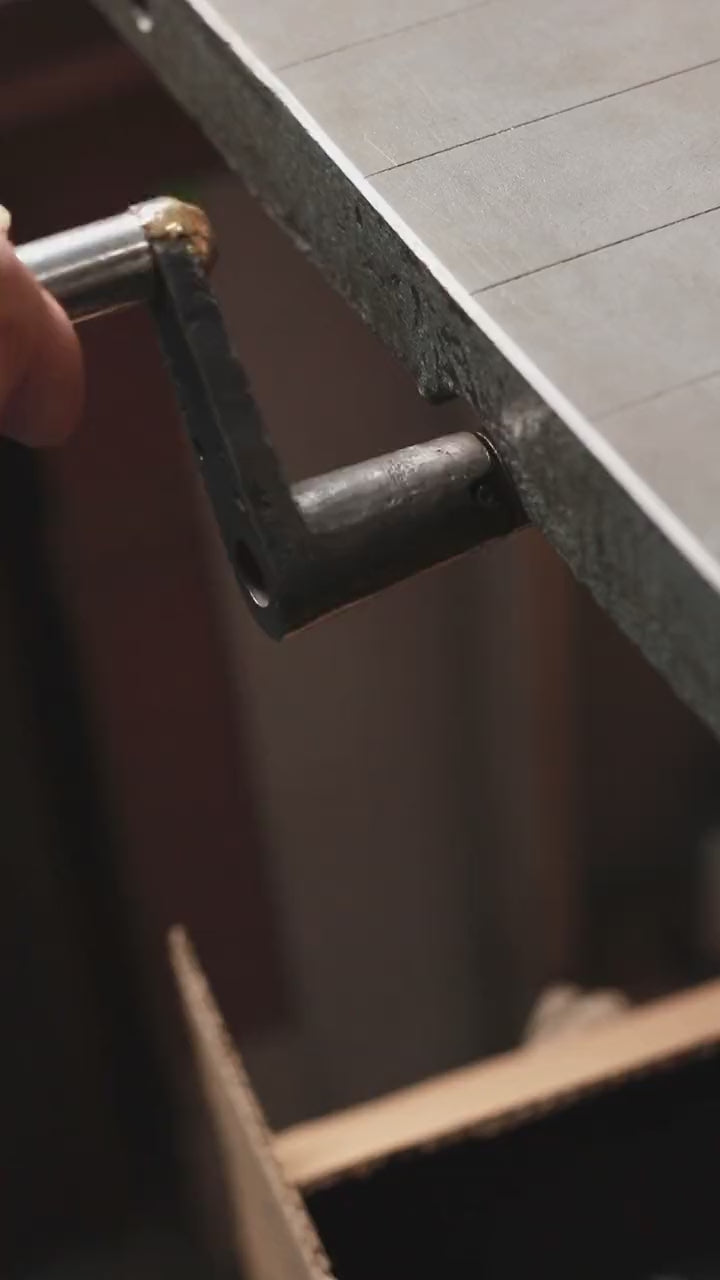 Load video: Video of the hand-cranked press wheel turning in the basenotes bindery.